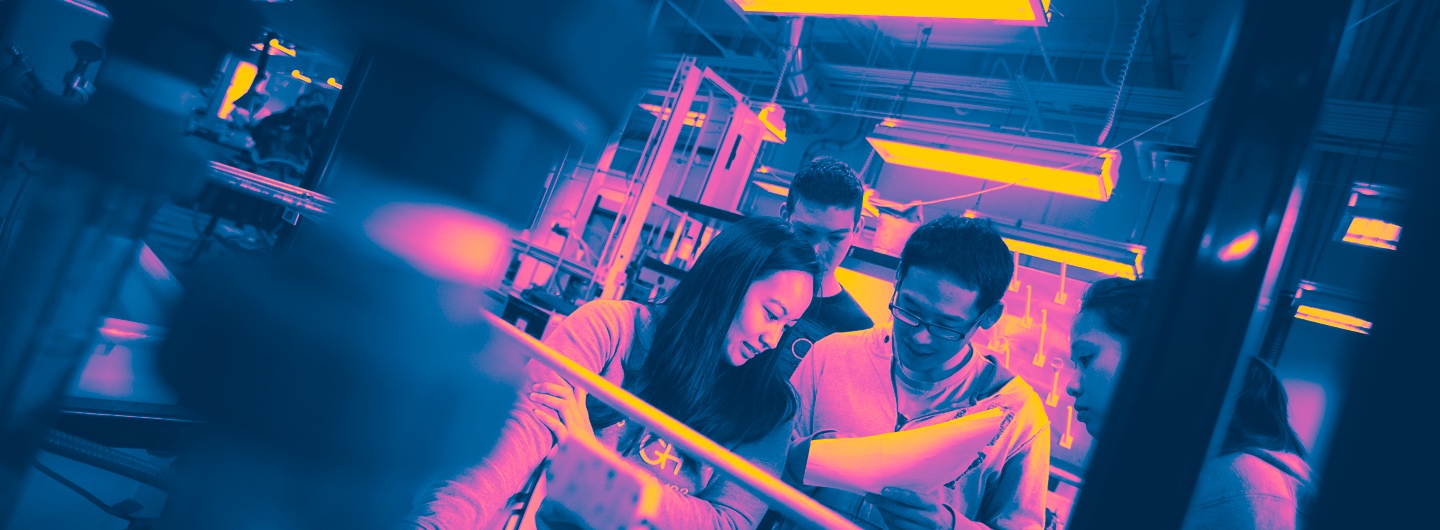 Students collaborating in the lab, with tones of pink and blue.